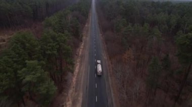 Dev tank kamyonunun ya da yakıt kamyonunun havadan görüntüsü. Ormanın asfalt yolunda, otoban manzaralı.