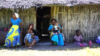 Zanzibar, Tanzanya - 13 Aralık 2019: Afrika ailesi Zanzibar, Tanzanya, Doğu Afrika 'da saman bir evin yanında oturuyor