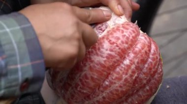 Sokak satıcısı Vietnamlı kadın, Kuzey Vietnam 'da, Hanoi' deki yerel bir yiyecek pazarında greyfurt soyuyordu.