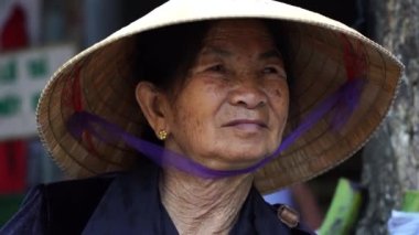 Hue, Vietnam - 12 Mart 2020: Vietnamlı yaşlı kadın hasır şapkalı Hue City, Vietnam 'da yerel bir yemek pazarında, yakın plan portresi