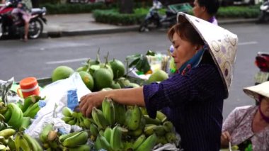 Ho Chi Minh, Vietnam - 23 Mart 2020: Vietnamlılar Ho Chi Minh, Vietnam şehir merkezindeki bir sokak gıda pazarında meyve ve sebze satıp alıyor.