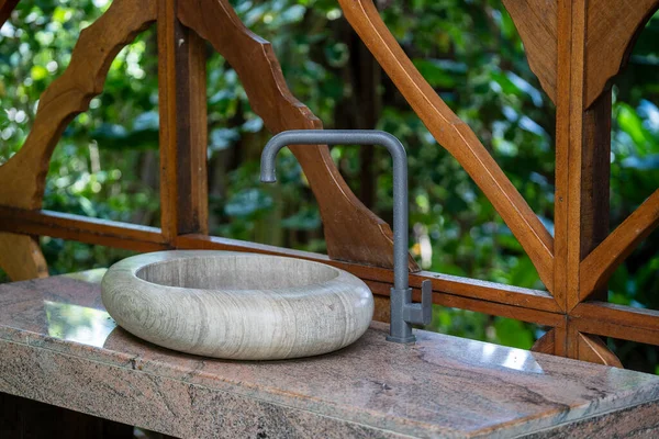 Natural organic stone sink washbasin in the summer tropical garden on Bali island in Indonesia. Close up