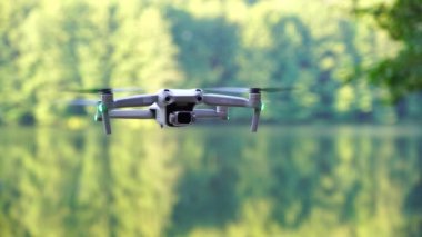 Kiev, Ukrayna - 01 Ekim 2021: DJI Maviç Air 2S İHA 'sı, bir önceki Maviç modeline göre büyük bir güncelleme yaparak, arka planda asılı duruyor. DJI Mavic Air 2S İHA 'sı orman gölünde uçuyor.