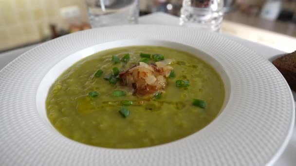 绿色豌豆奶油汤放在白盘上 桌上放香料 健康的食物 美味的干豌豆汤 — 图库视频影像