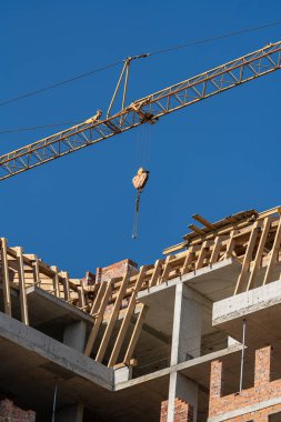 Turna ve bina mavi gökyüzüne karşı yapım aşamasında. Crane inşaat alanında çalışıyor.