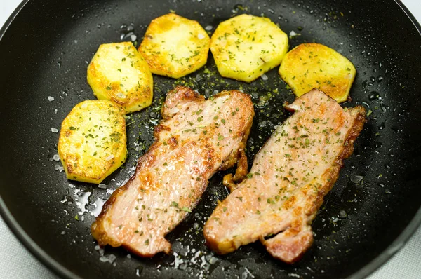 Bacon and potatoes in the pan. — Stock Photo, Image