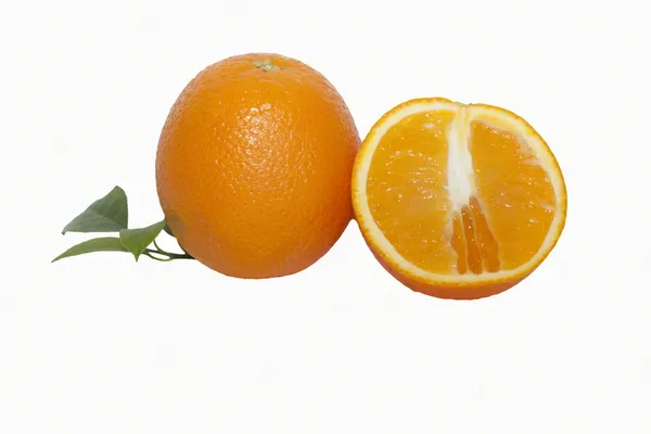 Mogen saftig apelsin med gröna blad på vit — Stockfoto