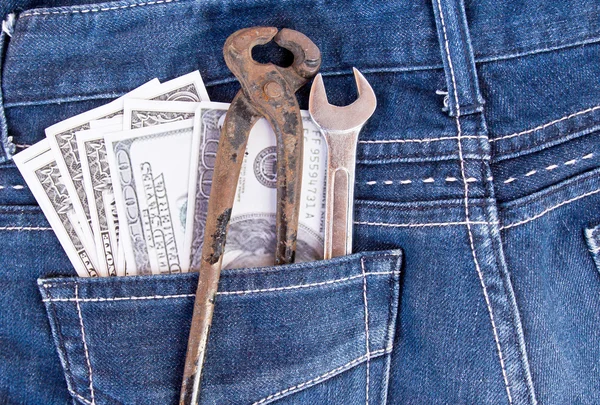 Notas de dólar americano e ferramentas no bolso jeans — Fotografia de Stock