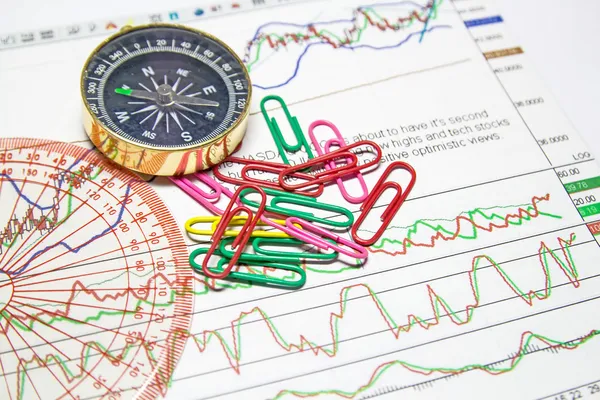 Business-stilleven van schaal, clips, kompas, op grafieken — Stockfoto