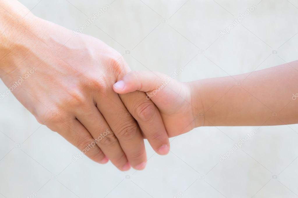 Close up mother holding a hand of his son