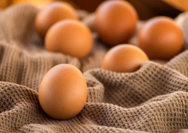 Kahverengi kumaş üzerinde yumurta natürmort — Stok fotoğraf