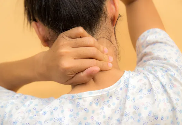 年轻妇女因在背部和颈部疼痛 — 图库照片