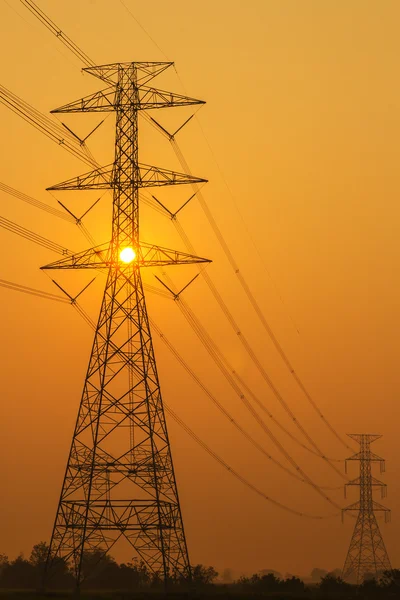 Alta silueta de postes eléctricos — Foto de Stock