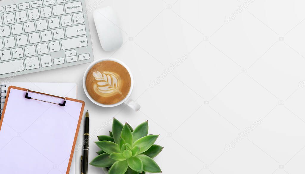 Office desk with stationary, keyboard,mouse,notebook,coffee and flower on white table background. Top view with copyspace. Concept for business.