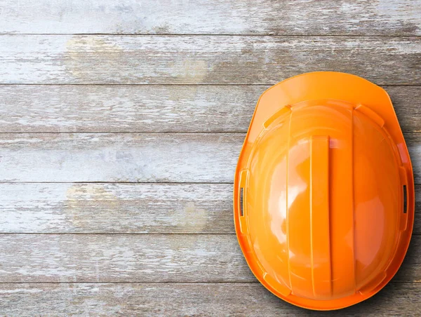 Top view with orange safety helmet on wood table background. copy space for design.