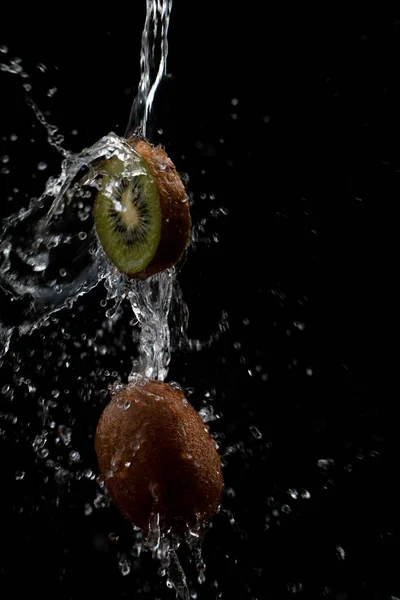 Plasterek Kiwi Całe Kiwi Oblane Dużą Ilością Wody Przed Czarnym — Zdjęcie stockowe