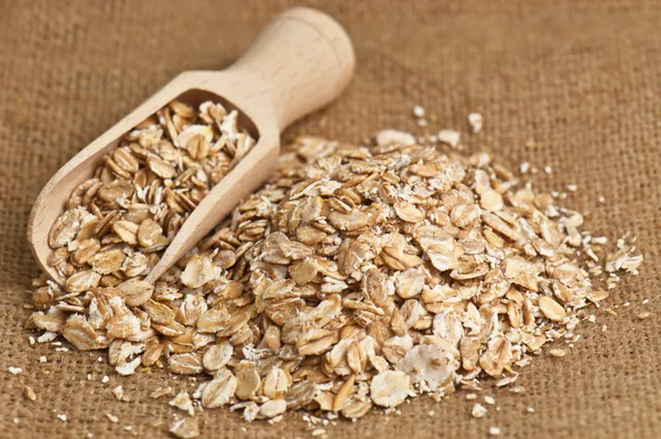 Oat flakes on burlap — Stock Photo, Image