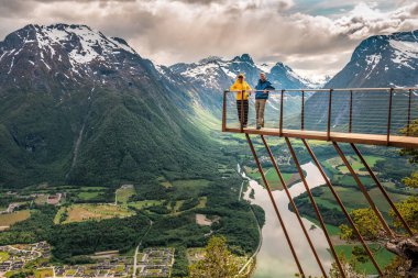 Andalsnes 'de Rampestreken' de duran sarı ve mavi elbiseli iki kişi. Norveç