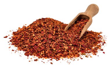 Beyaz arka planda izole edilmiş ahşap kepçeli bir biber yığını.