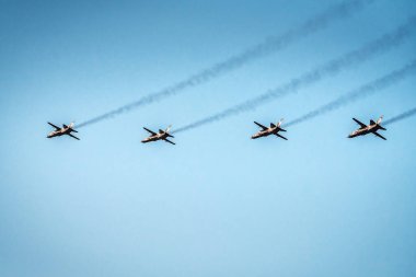 Mavi gökyüzünde dört askeri uçak uçuyor.