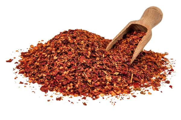 Beyaz arka planda izole edilmiş ahşap kepçeli bir biber yığını.