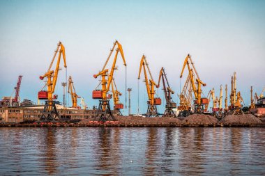 Günbatımında limanda endüstriyel vinçler