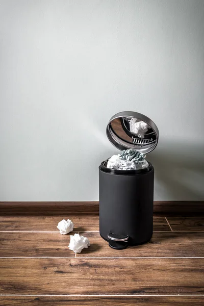 full office trash can on the laminate floor