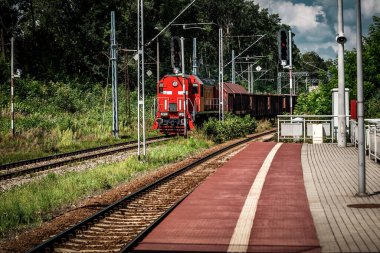 Yük treni güneşli yaz gününde demiryolunda hareket eder.