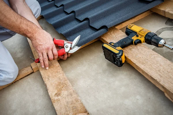 Professional Roofers Cut Metal Tile Using Cutting Pliers Stock Photo