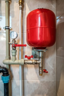 Kazan dairesinde kırmızı genişleme tankı ve boru hatları