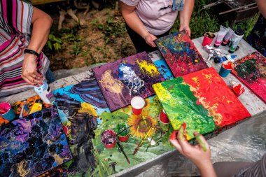 İnsanlar akışkan sanat teknikleri üzerinde çalışırken resimdeki akryl boyaları karıştırıyorlar. Komik zaman.