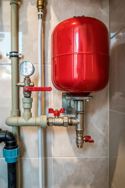 Kazan dairesinde kırmızı genişleme tankı ve boru hatları