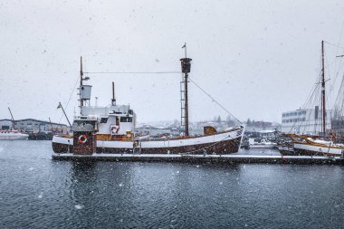 Kar fırtınası ve kar fırtınası sırasında limanda barınak arayan balıkçı teknesi.