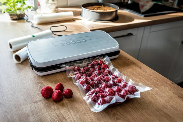 Vacuum strawberries packaging for long-term storage. They use of a vacuum sealer for long-term storage of products. Vacuum packing machine