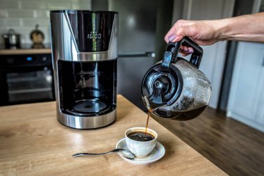 El, aromatik kahveyi fincana doldurur.