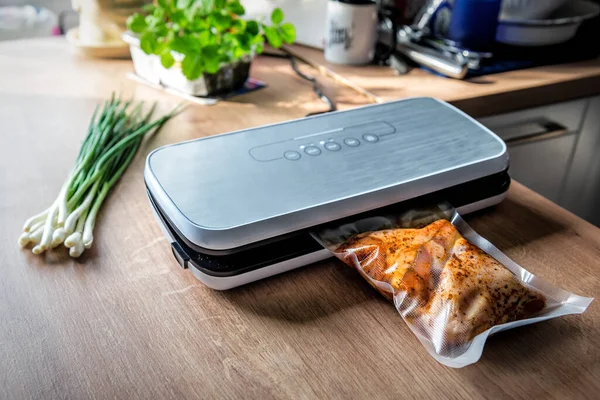 Eti plastik poşetlere koymak için vakumlu mühür (ambalaj) makinesi kullanılıyor. Bir demet yeşil soğan dalı