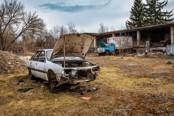 Wrecks of rusty abandoned car with opened hood
