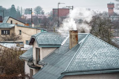 Kalın duman, bir evin çatısındaki tuğla bacadan gelir. Gaz krizi teması