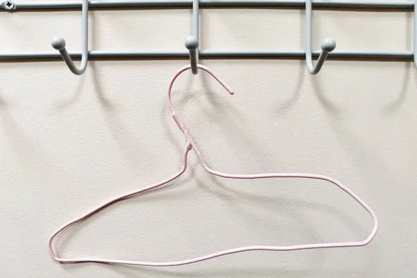 Pink Curved Old Clothes Hanger Hanging Hook Empty Wall Background — Stock Photo, Image