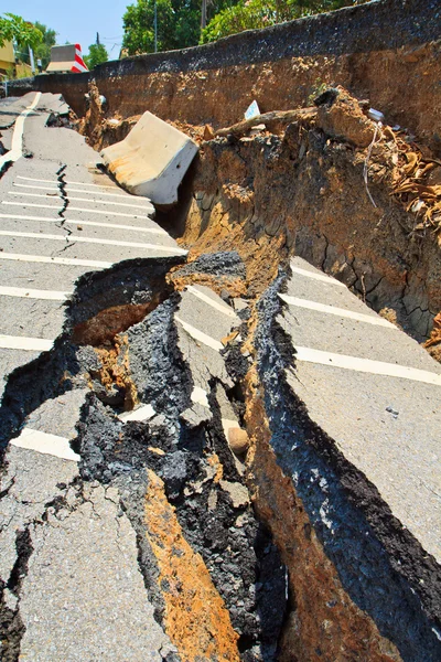 Superfície rachada de uma estrada de asfalto — Fotografia de Stock