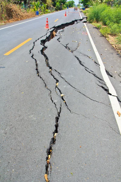 Superfície rachada de uma estrada de asfalto — Fotografia de Stock