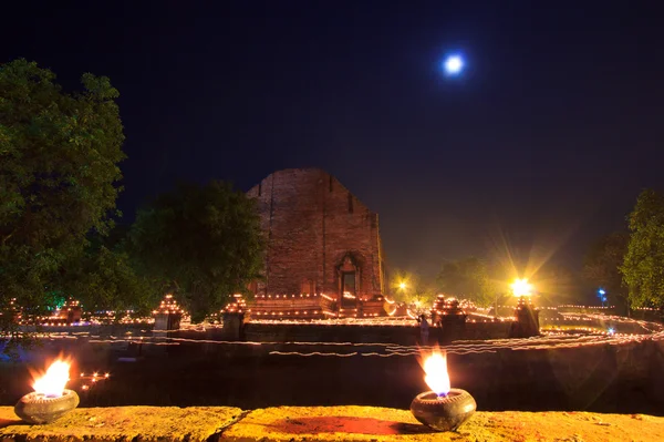 Wandelen met brandende kaarsen in hand rond een tempel — Stockfoto