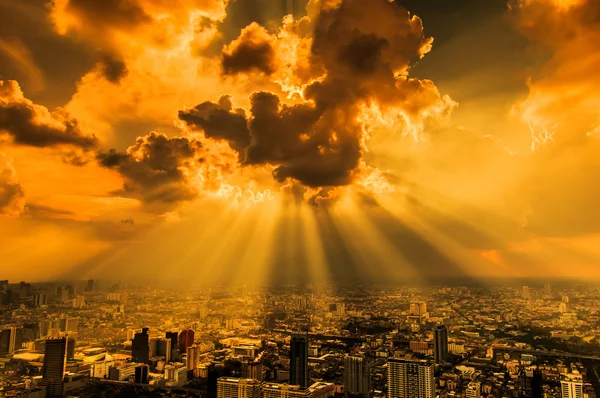 Raios de luz brilhando através de nuvens escuras da cidade — Fotografia de Stock