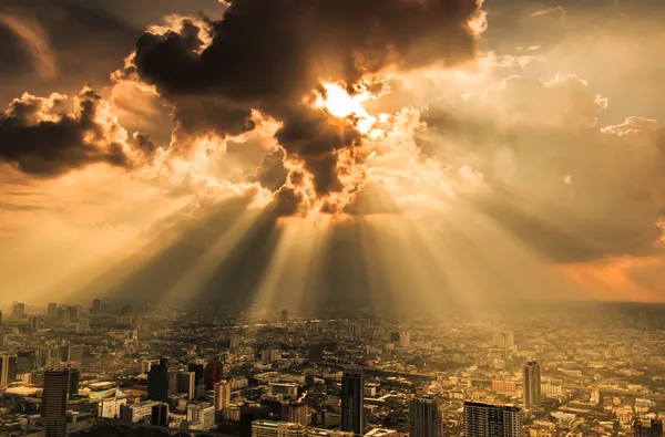 Rayons de lumière brille à travers les nuages sombres ville — Photo