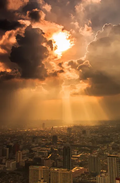 Raios de luz brilhando através de nuvens escuras da cidade — Fotografia de Stock