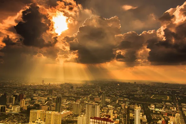 Rays of light shining through dark clouds city — Stock Photo, Image