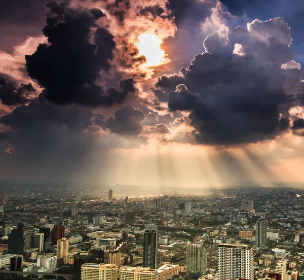 Karanlık bulutlar şehrinde parlayan ışık huzmeleri — Stok fotoğraf