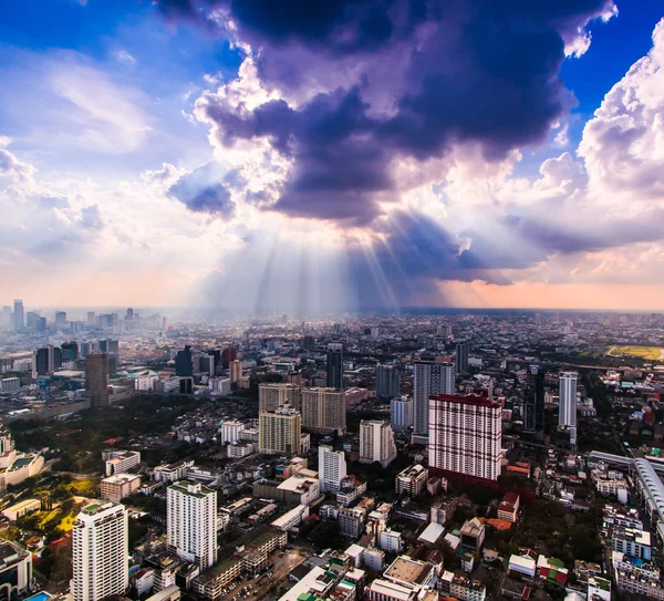 Raios de luz brilhando através de nuvens escuras da cidade — Fotografia de Stock