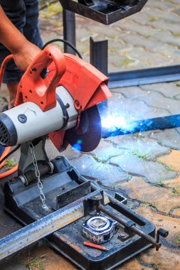 Öğütücüyle metal kesen bir işçi