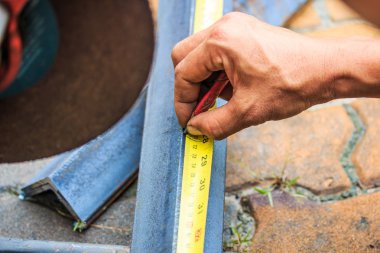 Öğütücüyle metal kesen bir işçi